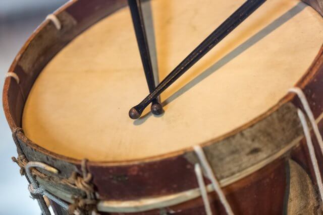 Closeup photo of old military drum with black sticks
